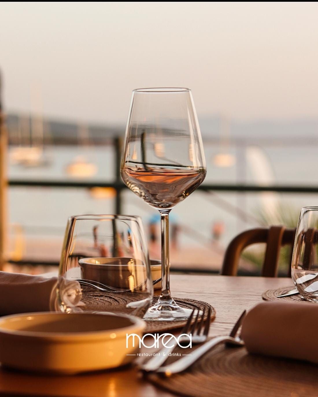 Due bicchieri di vino sono appoggiati su un tavolo di legno.