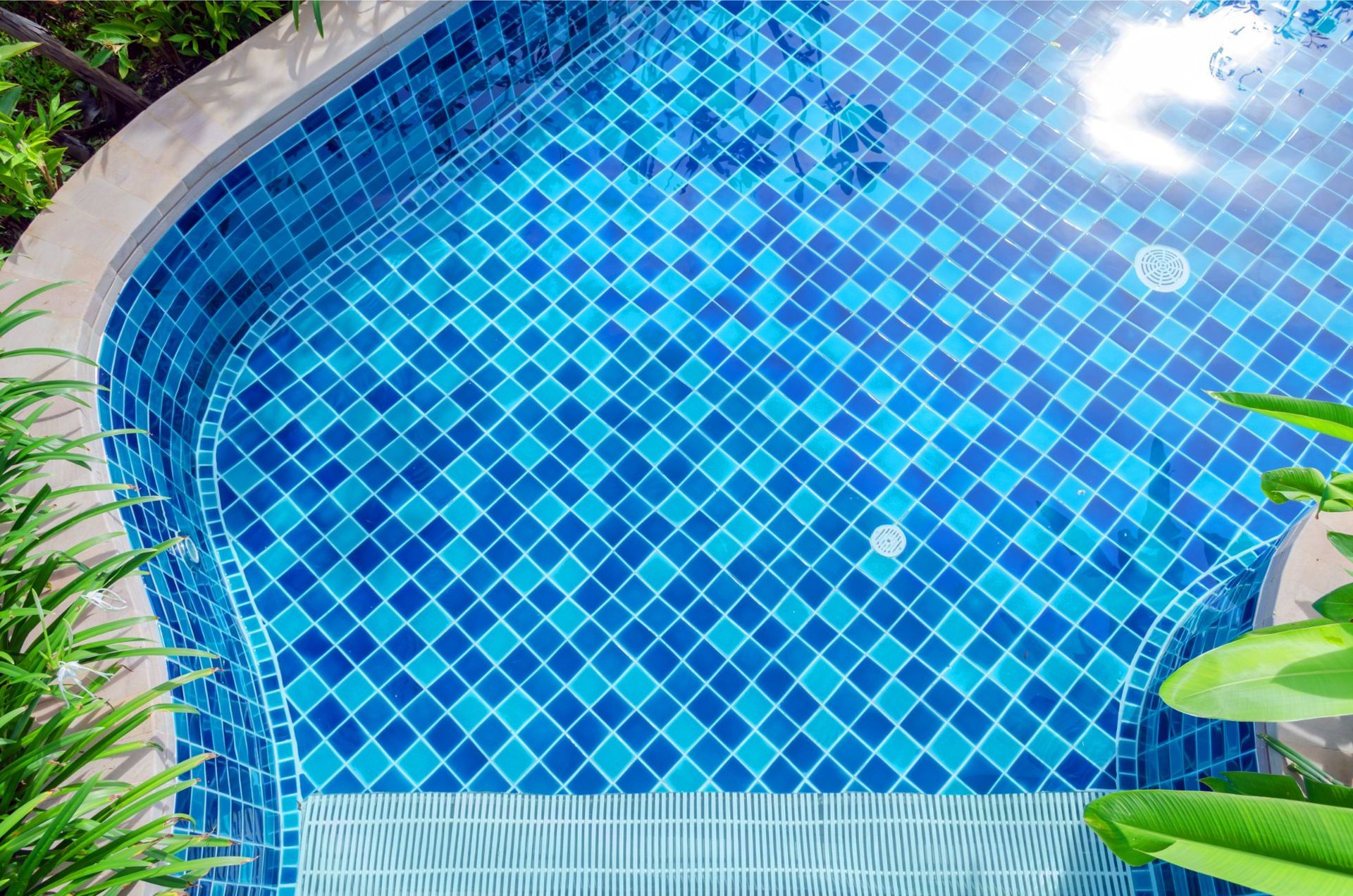 Blue tiled swimming pool with rounded corners.