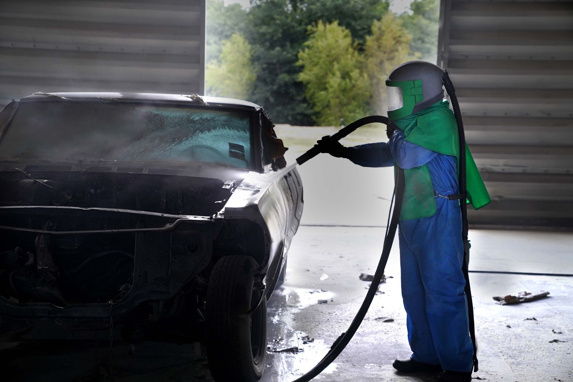 A man is cleaning a car with a high pressure washer.