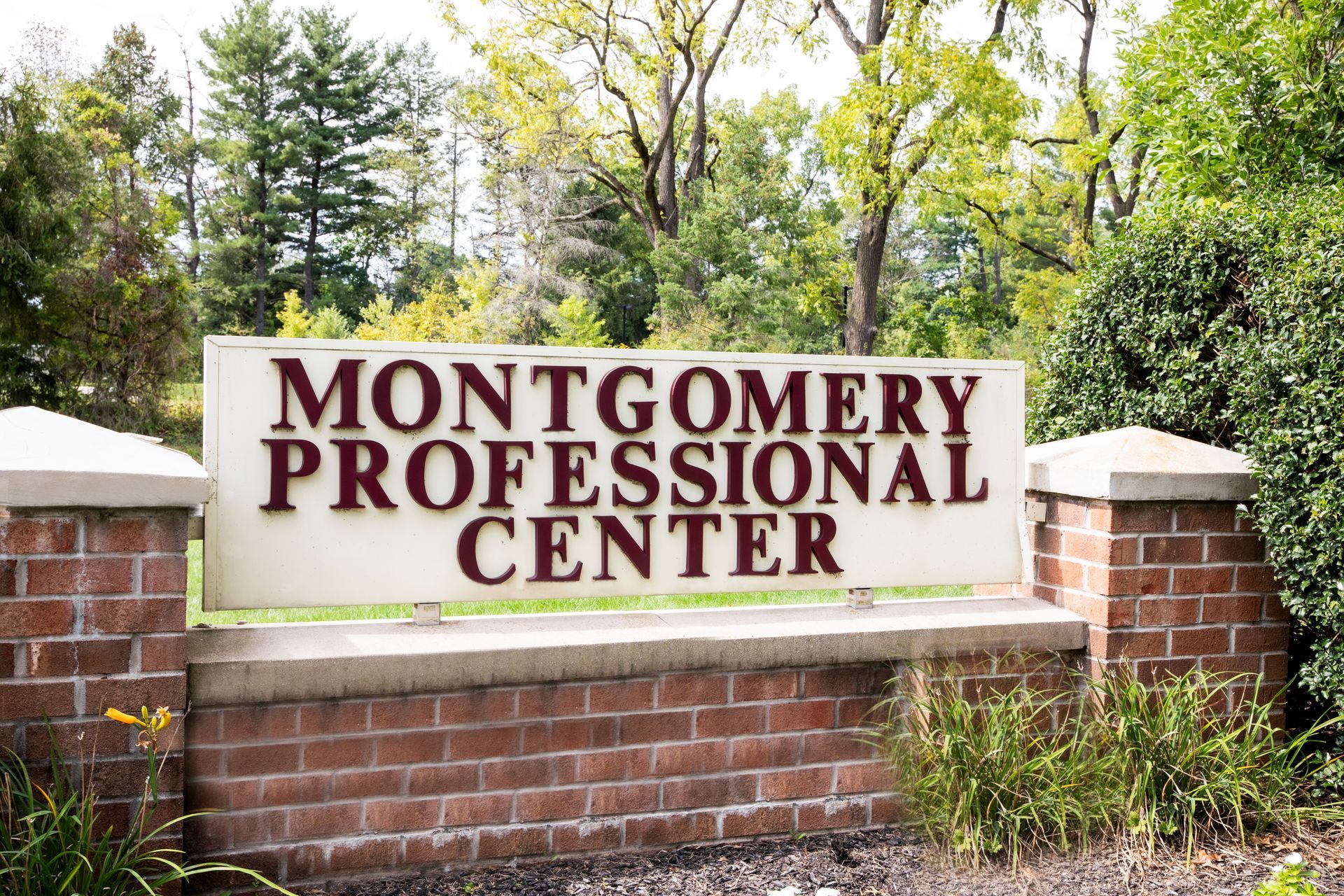 A white sign on a brick wall says montgomery professional center