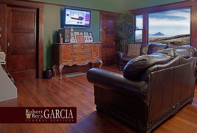 Elegant living room with leather sofa, wood dresser, TV, and large scenic window view