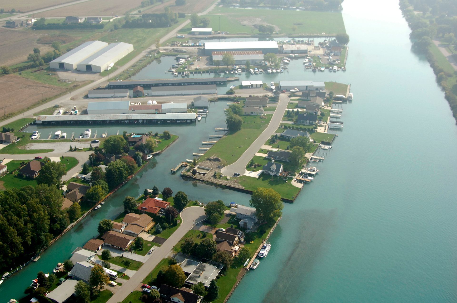 Aerial view of a canal with boats, docks, houses, and commercial buildings along the water.