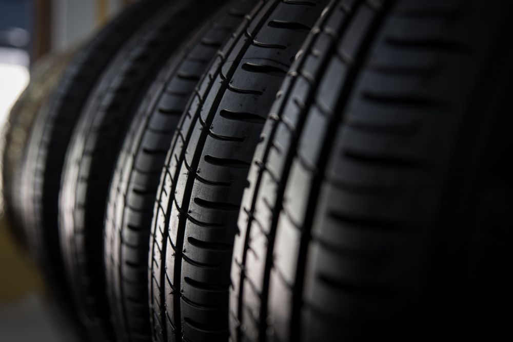 Close-up of stacked black car tires in a dimly lit showroom