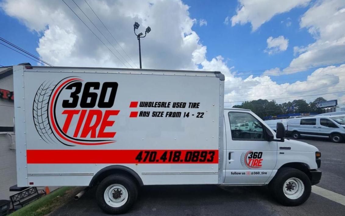 White 360 Tire service truck with red logo parked outdoors under a cloudy sky