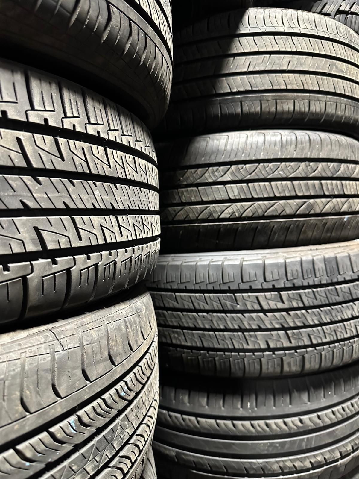 Stacks of black car tires piled in a storage area.