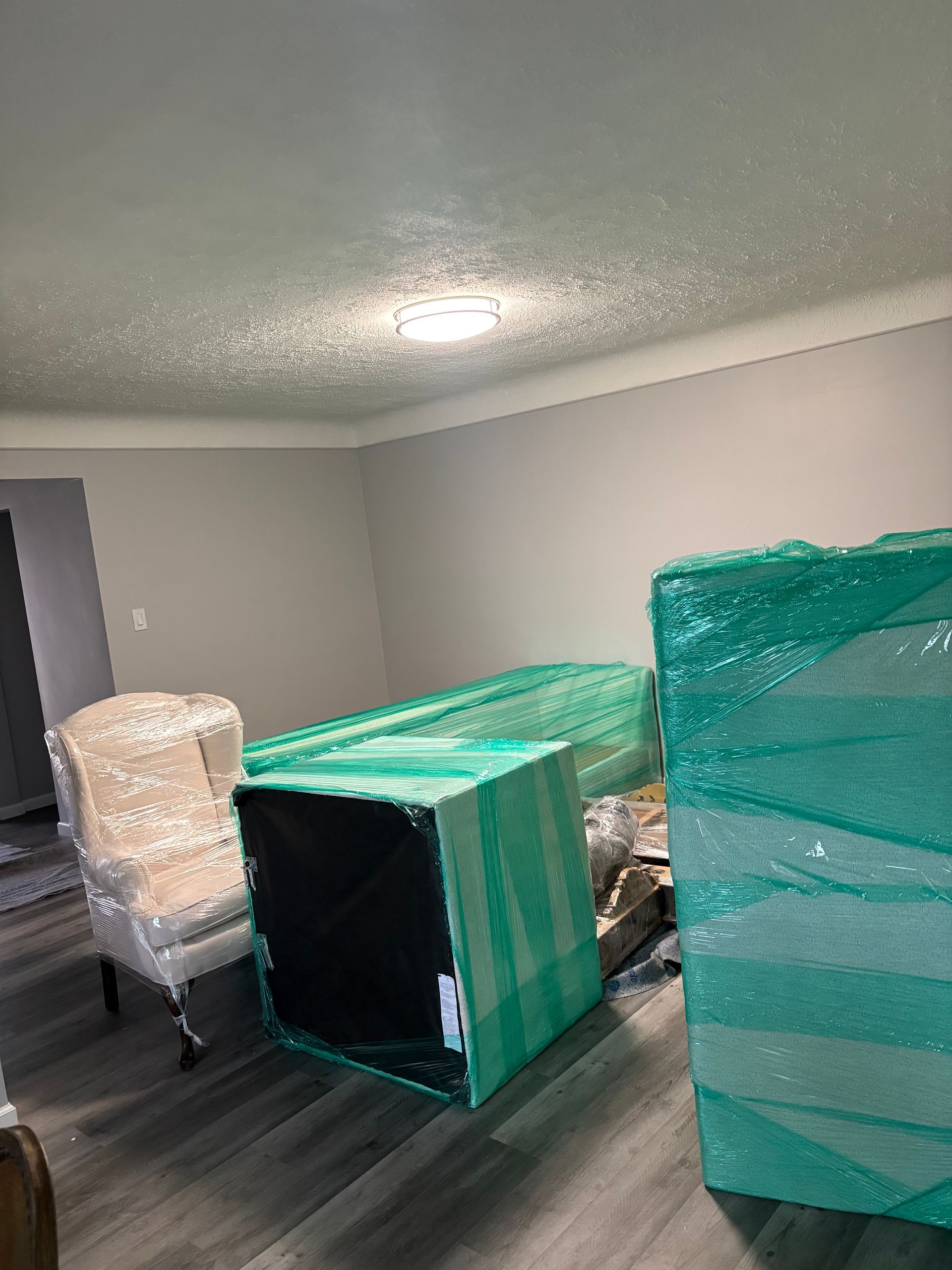 Office workers and a professional mover in a safety vest coordinate furniture relocation in a modern office space. Office workers and a professional mover in a safety vest coordinate furniture relocation in a modern office space.
