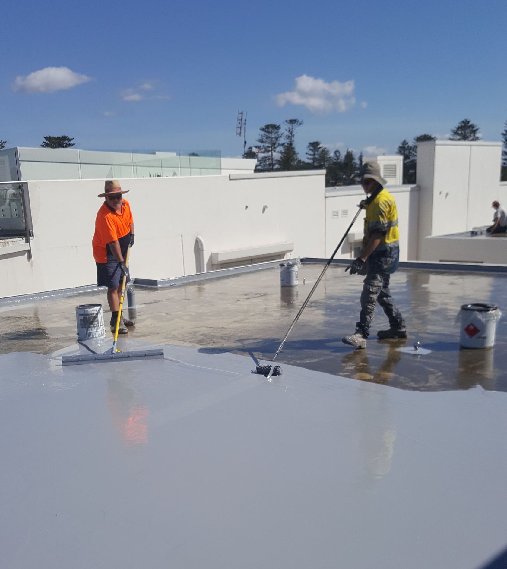 Man utilising a paint roller for waterproofing a sheet with precision and expertise — Leak Free Waterproofing in Dapto, NSW