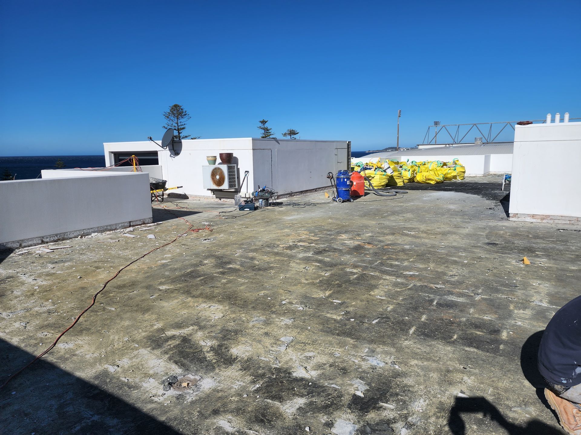 Workers applying waterproofing on the terrace, ensuring a leak-free surface — Leak Free Waterproofing in Unanderra, NSW