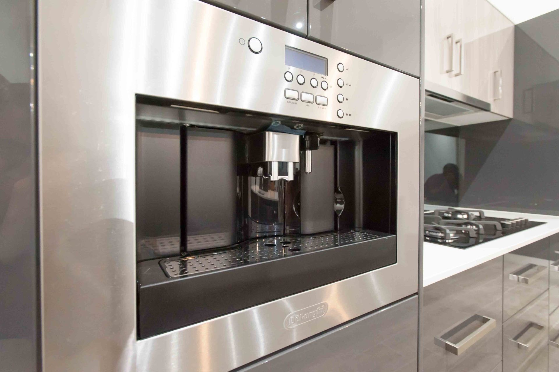 Stainless Steel Built-in Coffee Machine In A Modern Kitchen With Gray Cabinets And Countertops — B & C Cabinets in Mareeba, QLD