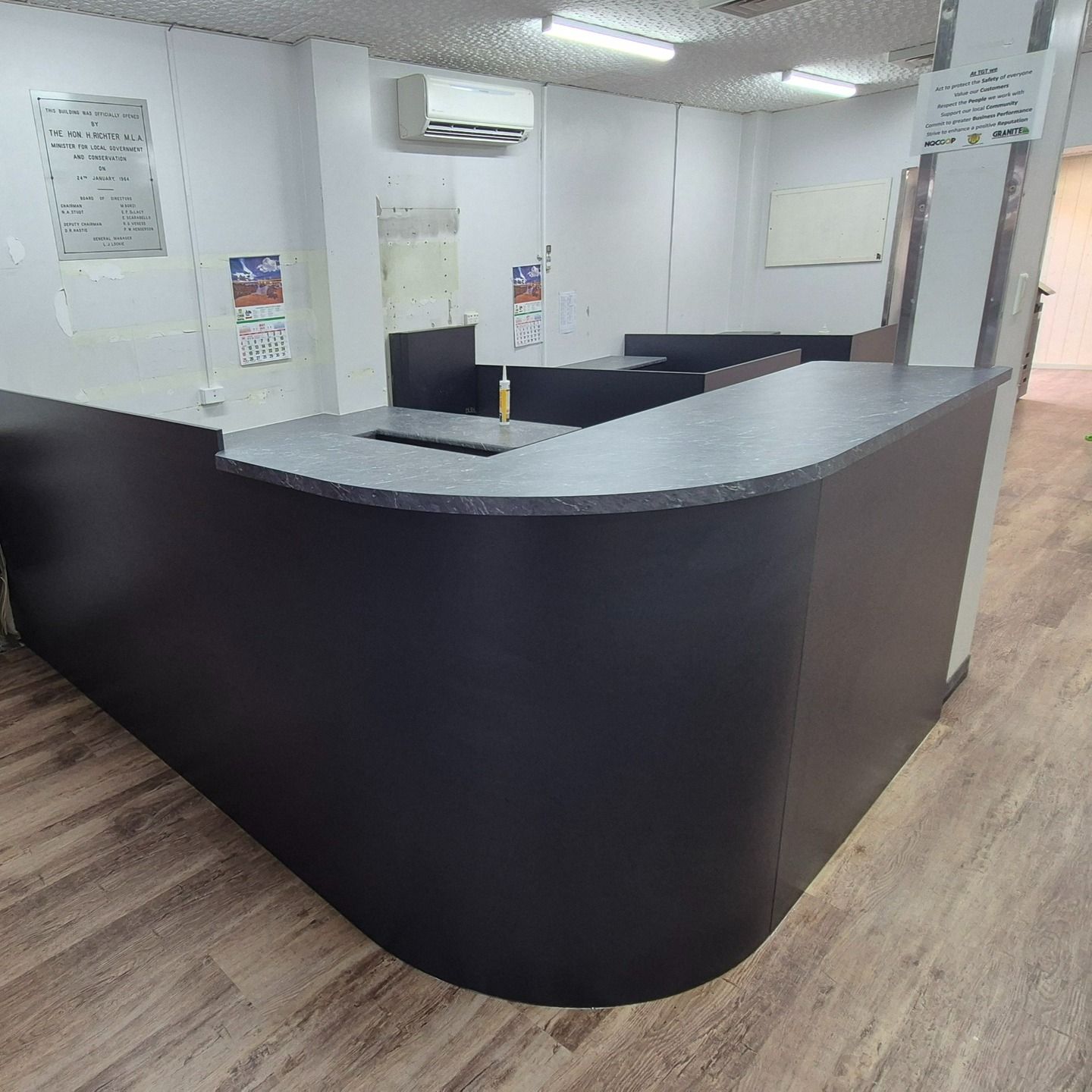 Black Curved Office Reception Desk With Gray Countertop — B & C Cabinets in Mareeba, QLD
