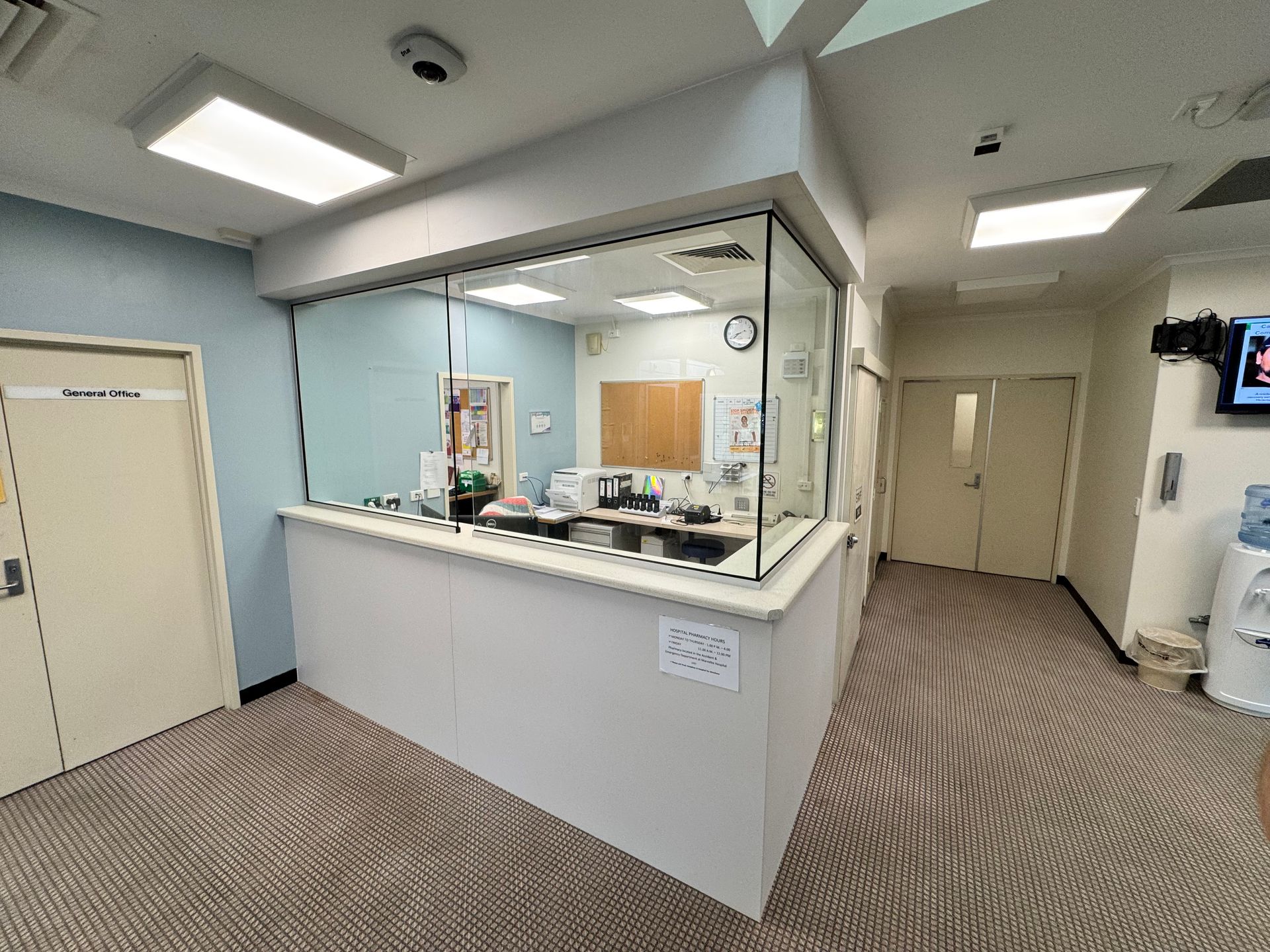Reception Area With White Counter, Glass Window, And Two Doors. Carpeted Floor — B & C Cabinets in Mareeba, QLD