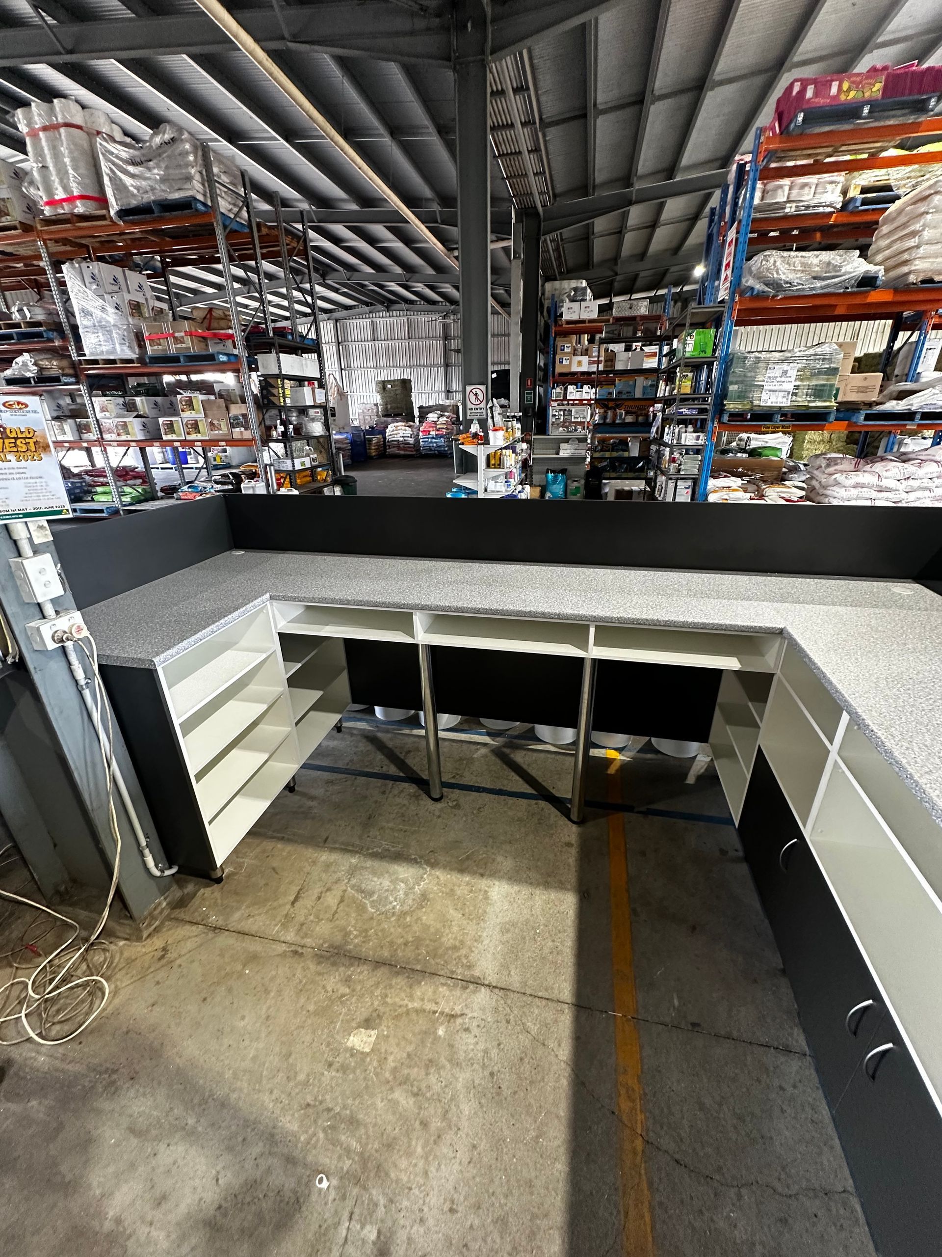 U-shaped Countertop With Shelves And Drawers In A Warehouse Setting — B & C Cabinets in Mareeba, QLD