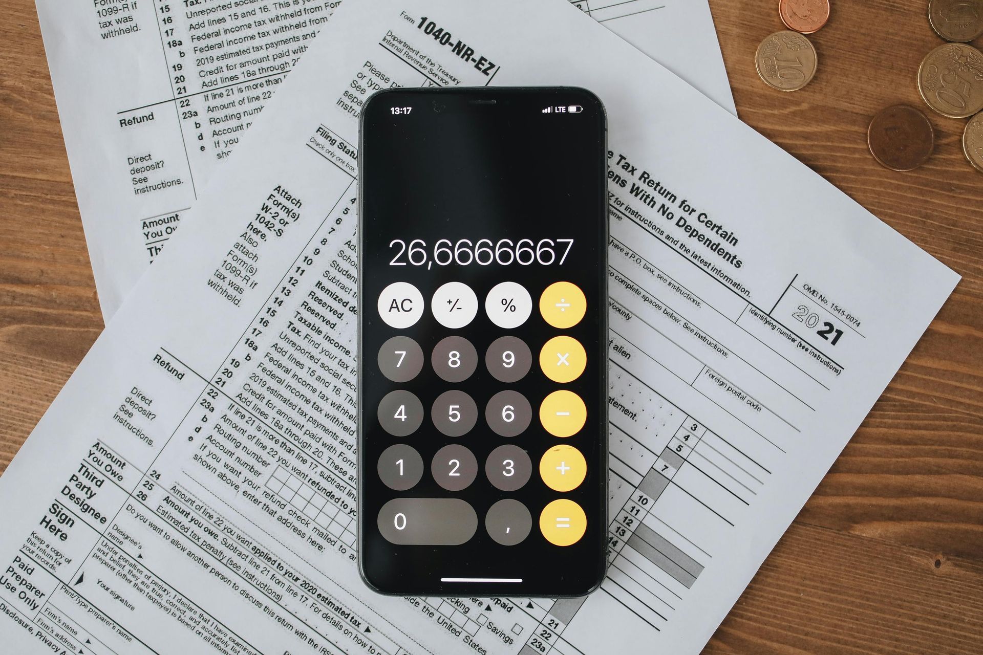 A cell phone is sitting on top of a pile of tax forms.