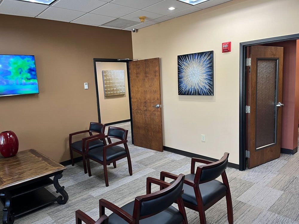 A waiting room with chairs and a television on the wall.