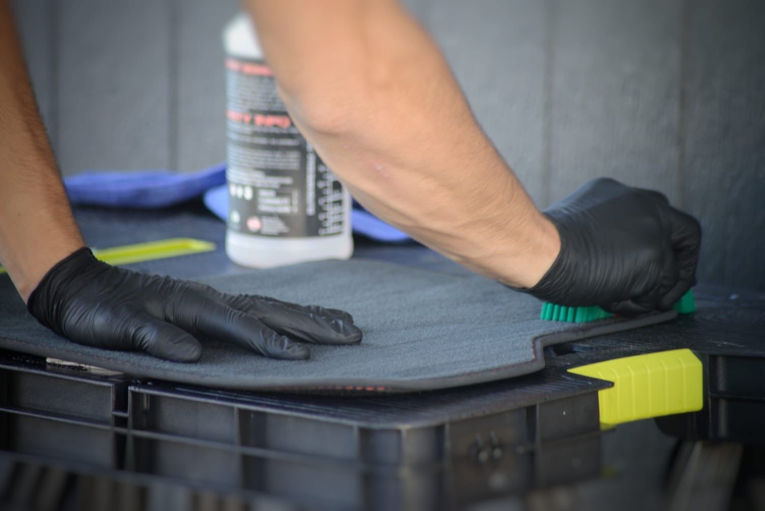 A Person is Scrubbing the Carpets of a Car — Best Car Detailing in Vincent, QLD