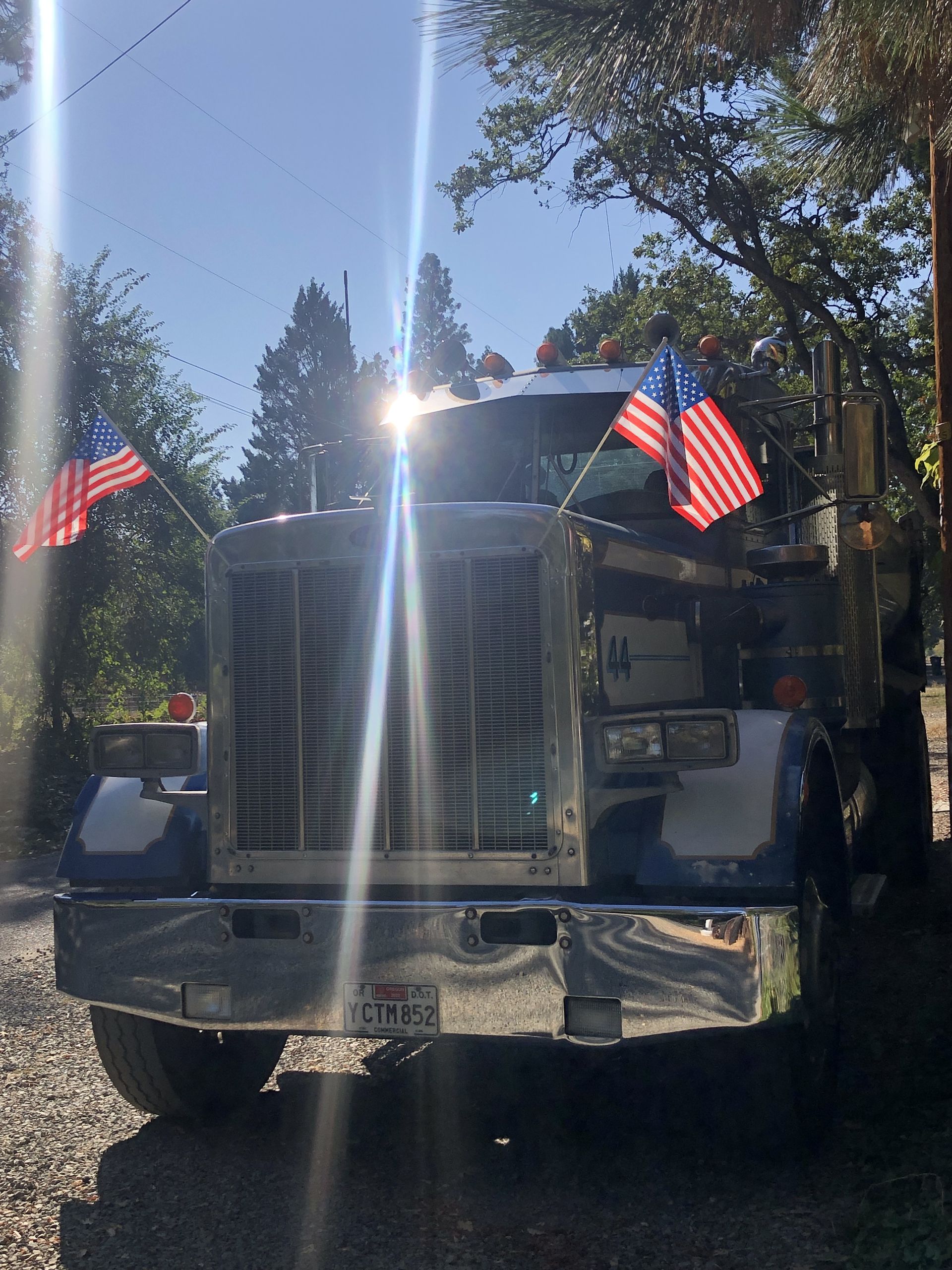A semi truck with american flags on top of it