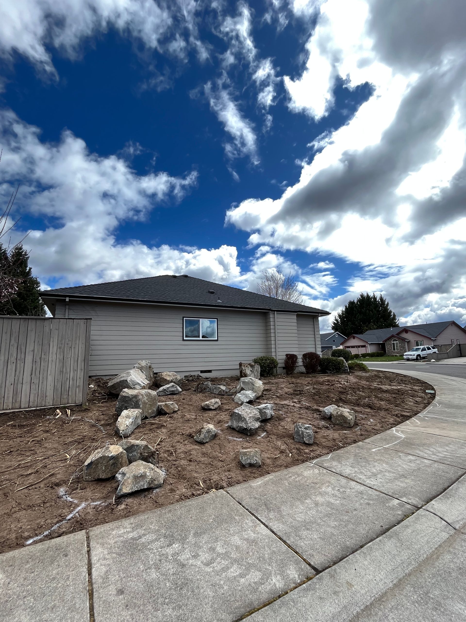 A house with a lot of rocks in front of it on a cloudy day.