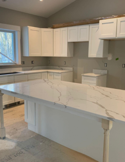 A kitchen with white cabinets and a large counter top