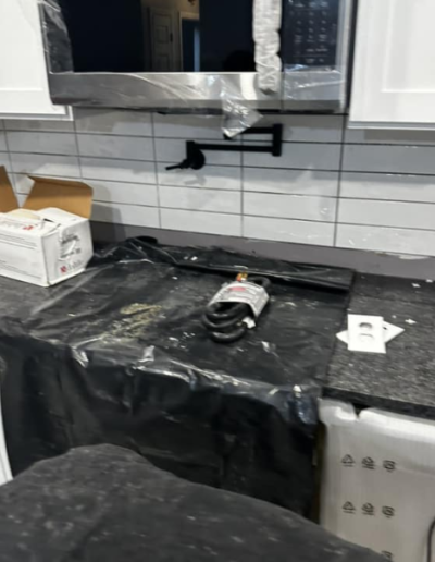 A black plastic bag is covering a counter in a kitchen