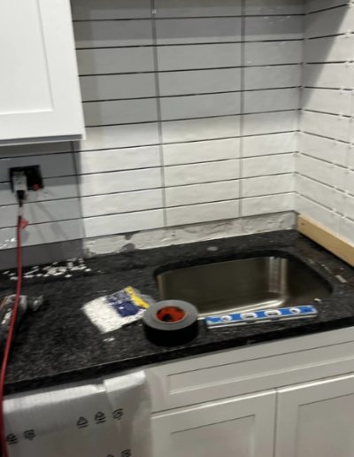 A kitchen counter with a sink and a roll of tape on it