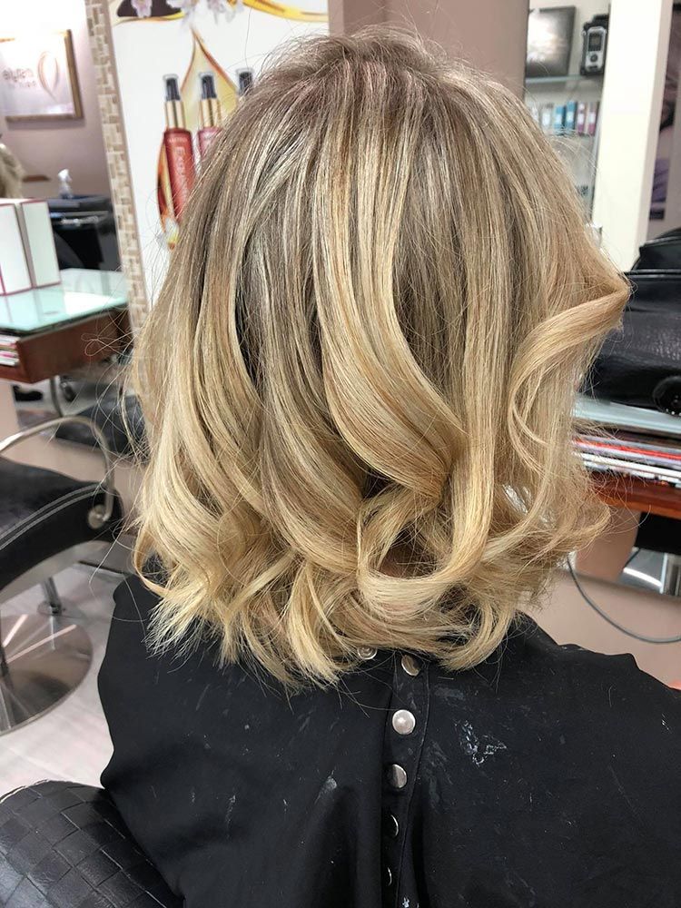 A Woman With Blonde Hair is Sitting in a Chair in a Salon — Instyle Hair on B in Berserker, QLD