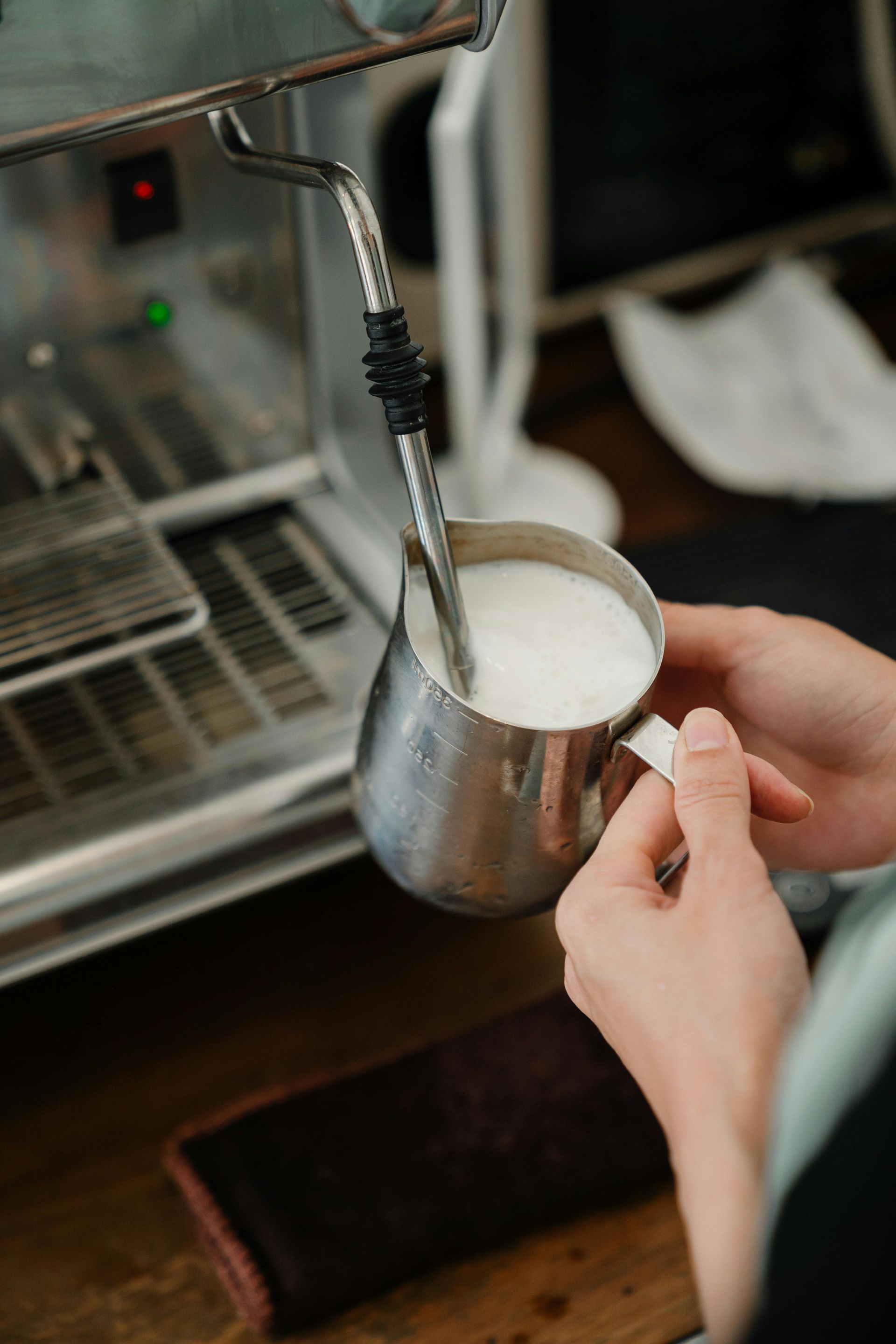A Barista Frothing Milk — Scotto's Food Logistics in Mitchell, ACT