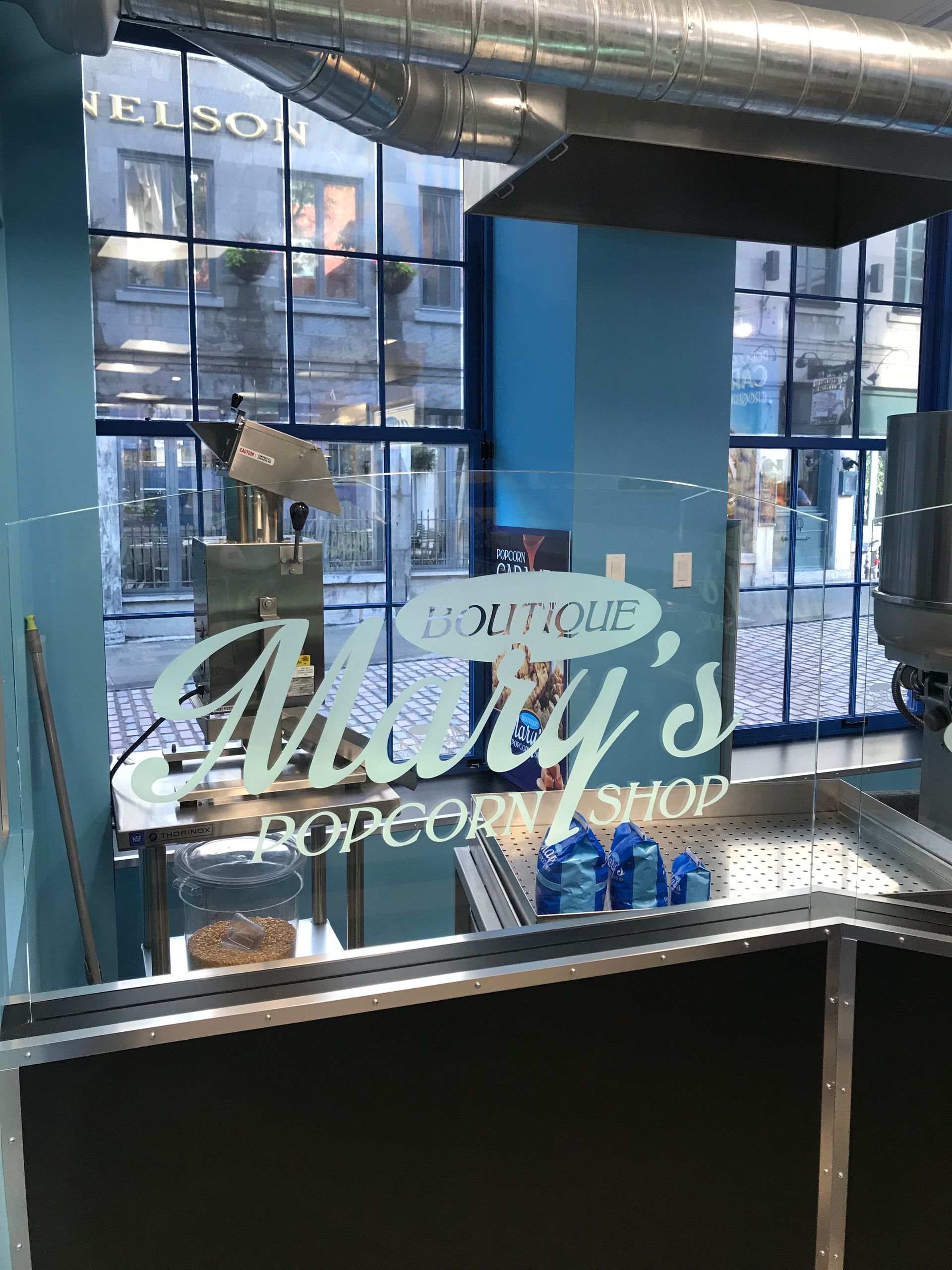 Bakery counter with glass display, hanging pastries, and “Jolly’s” signage in a bright café interior