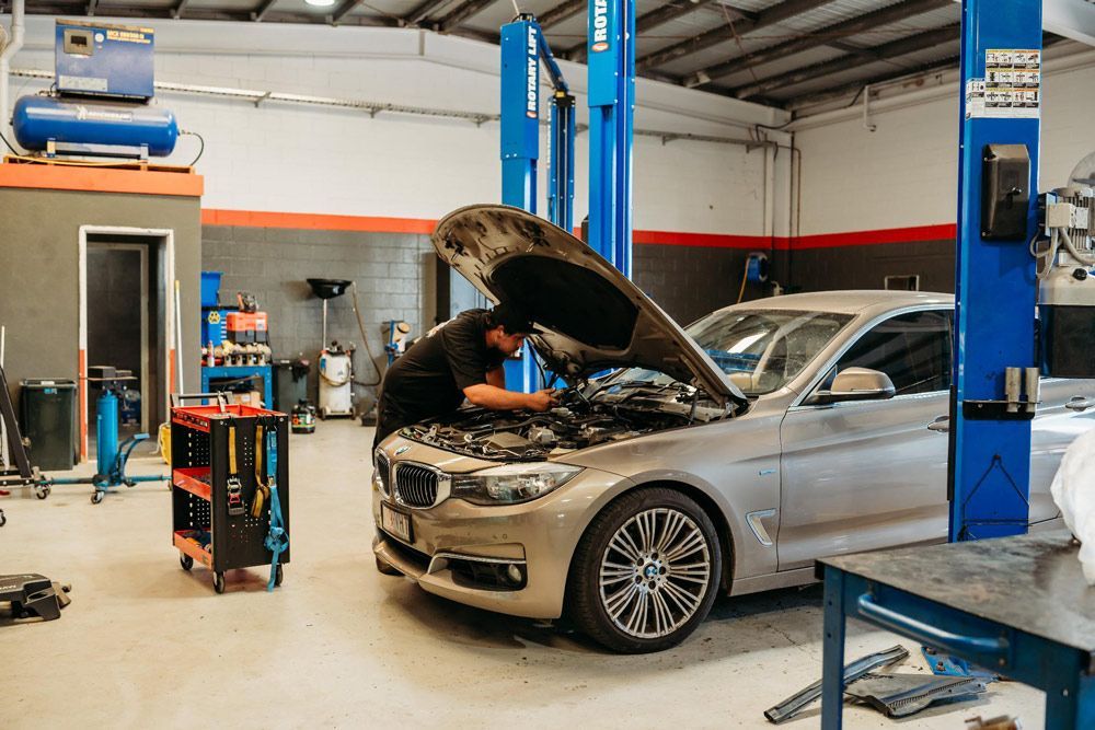 Man Servicing a Car in A Garage
