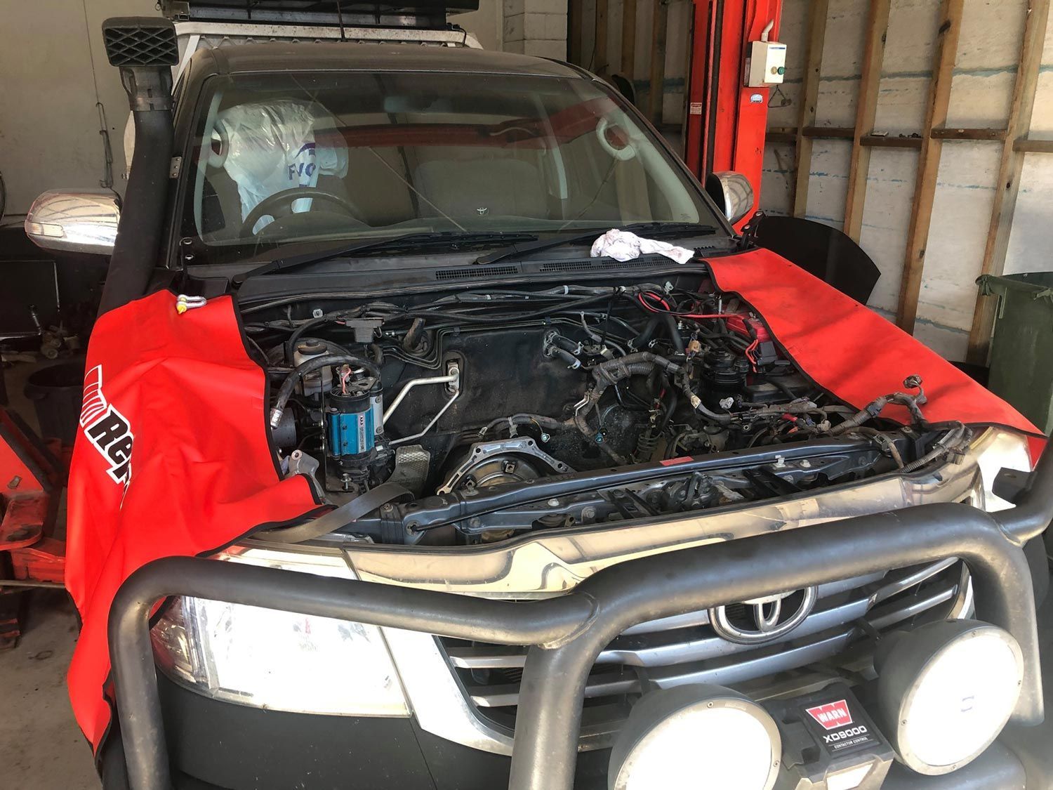 A Man Is Working On A Truck With The Hood Open — Signature Mechanical In South Gladstone, QLD