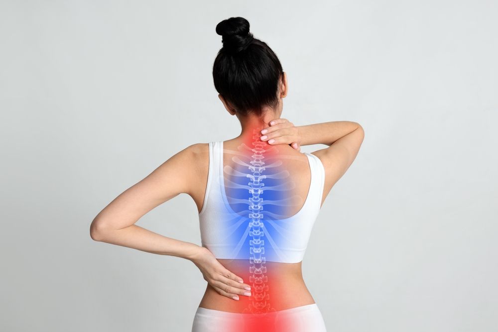 Person holding neck and lower back with red and blue pain highlights on spine