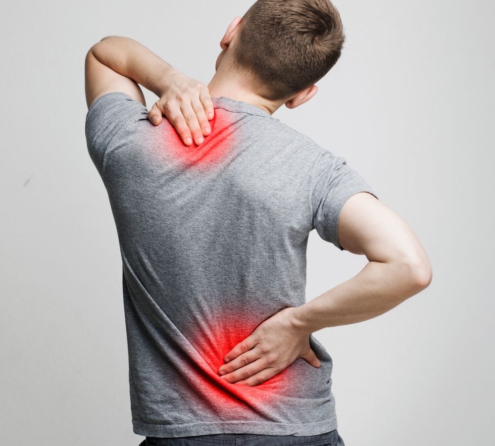 Man holding his neck and lower back, with red highlights indicating pain on a gray background