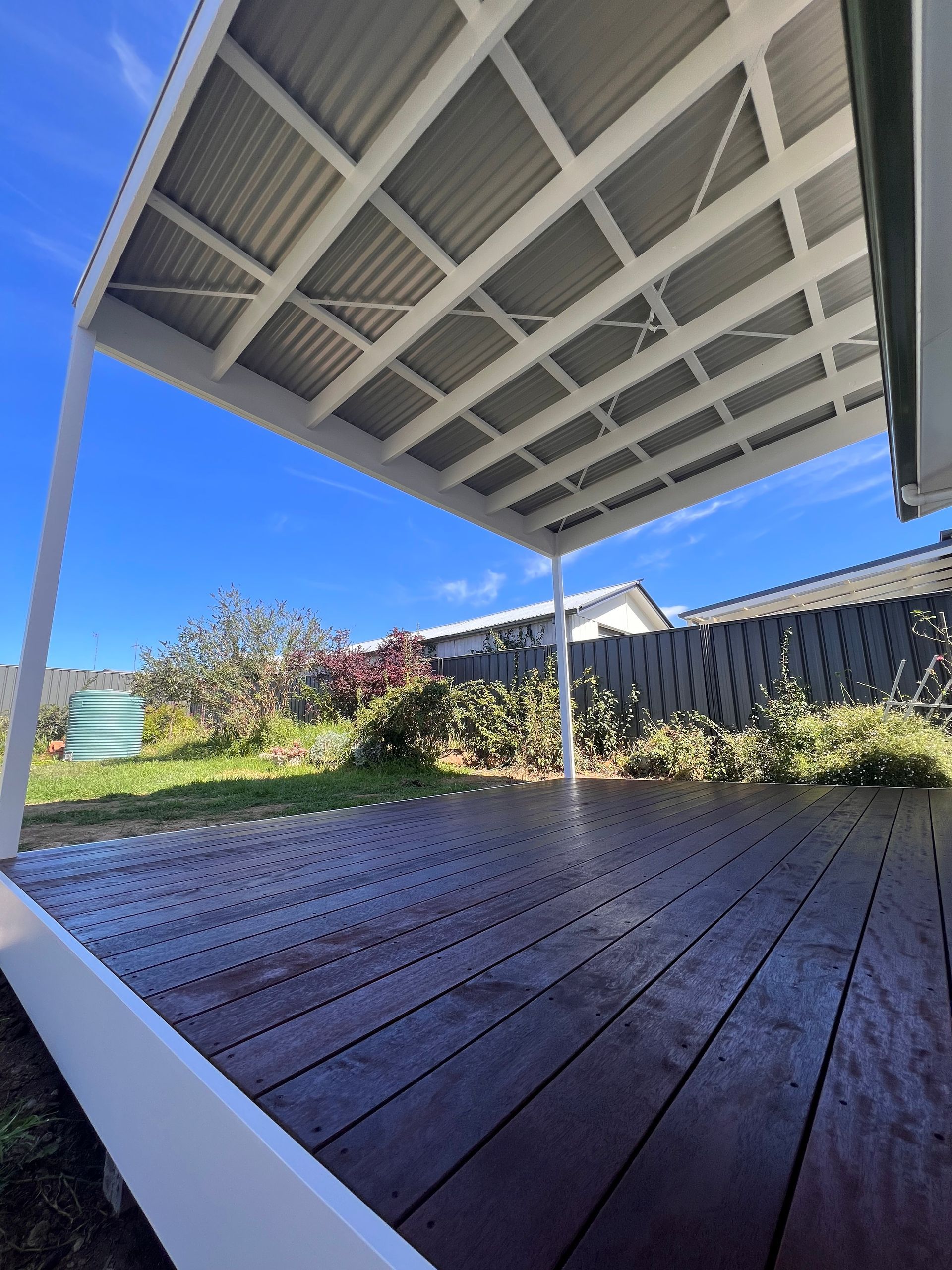 Wooden Deck With White Pergola Roof Under a Blue Sky — J&C Quality Construction in Goulburn, NSW