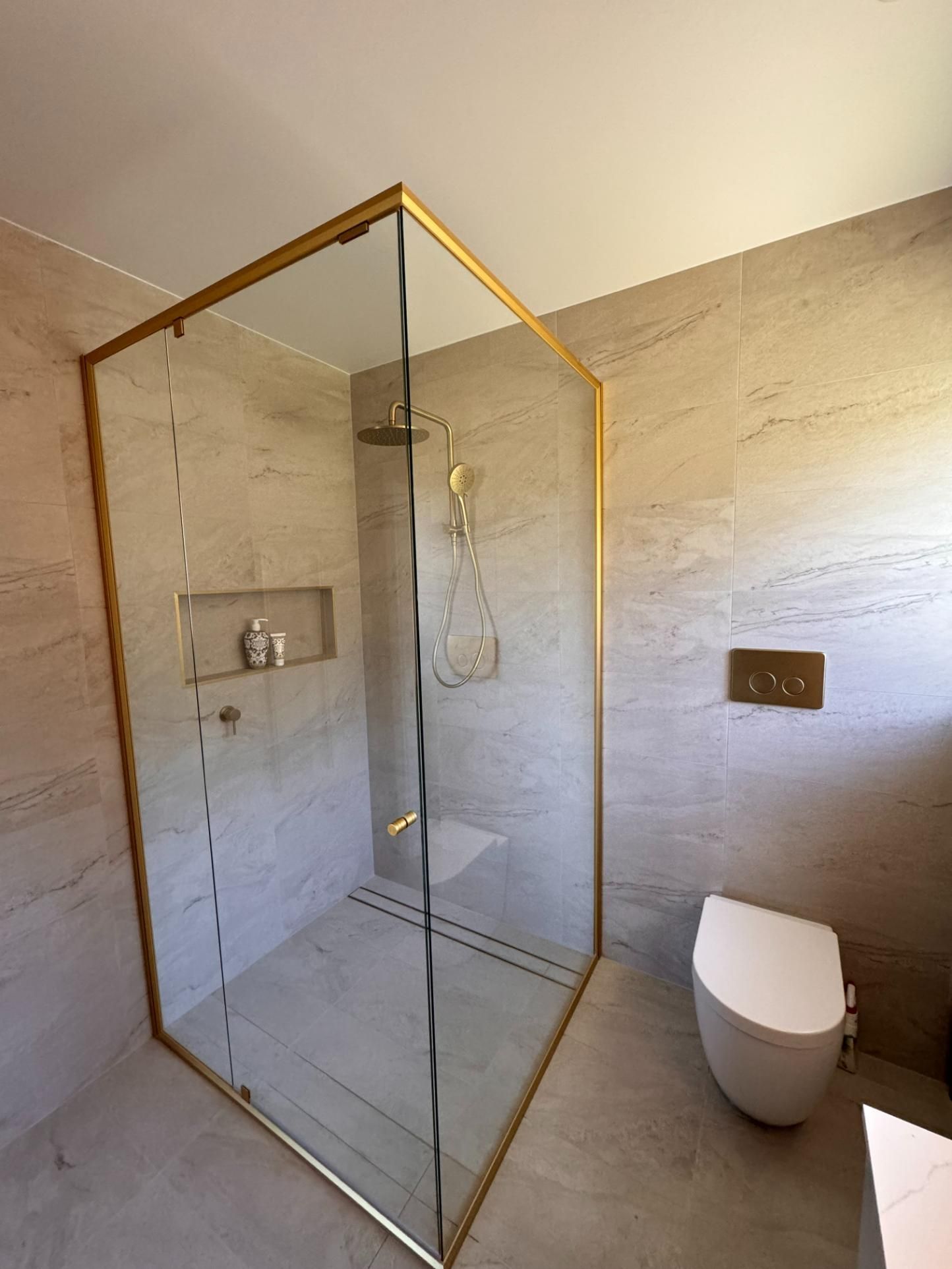 Modern Bathroom With a Gold-framed Glass Shower — J&C Quality Construction in Goulburn, NSW