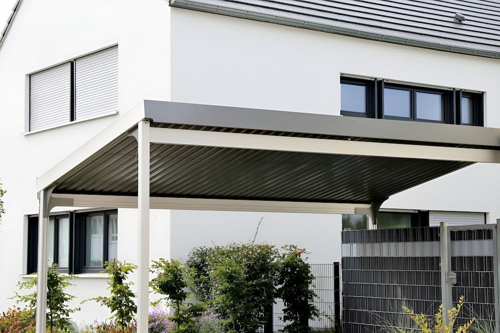 Carport With Corrugated Roof Attached to a White House — J&C Quality Construction in Southern Highlands, NSW