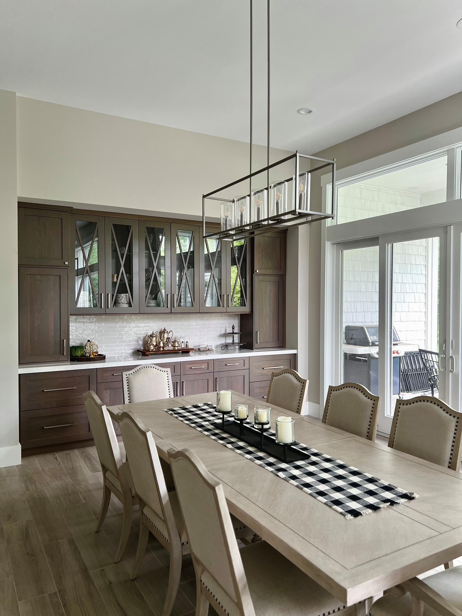 Formal dining room with long table set for guests; dark wood cabinetry.