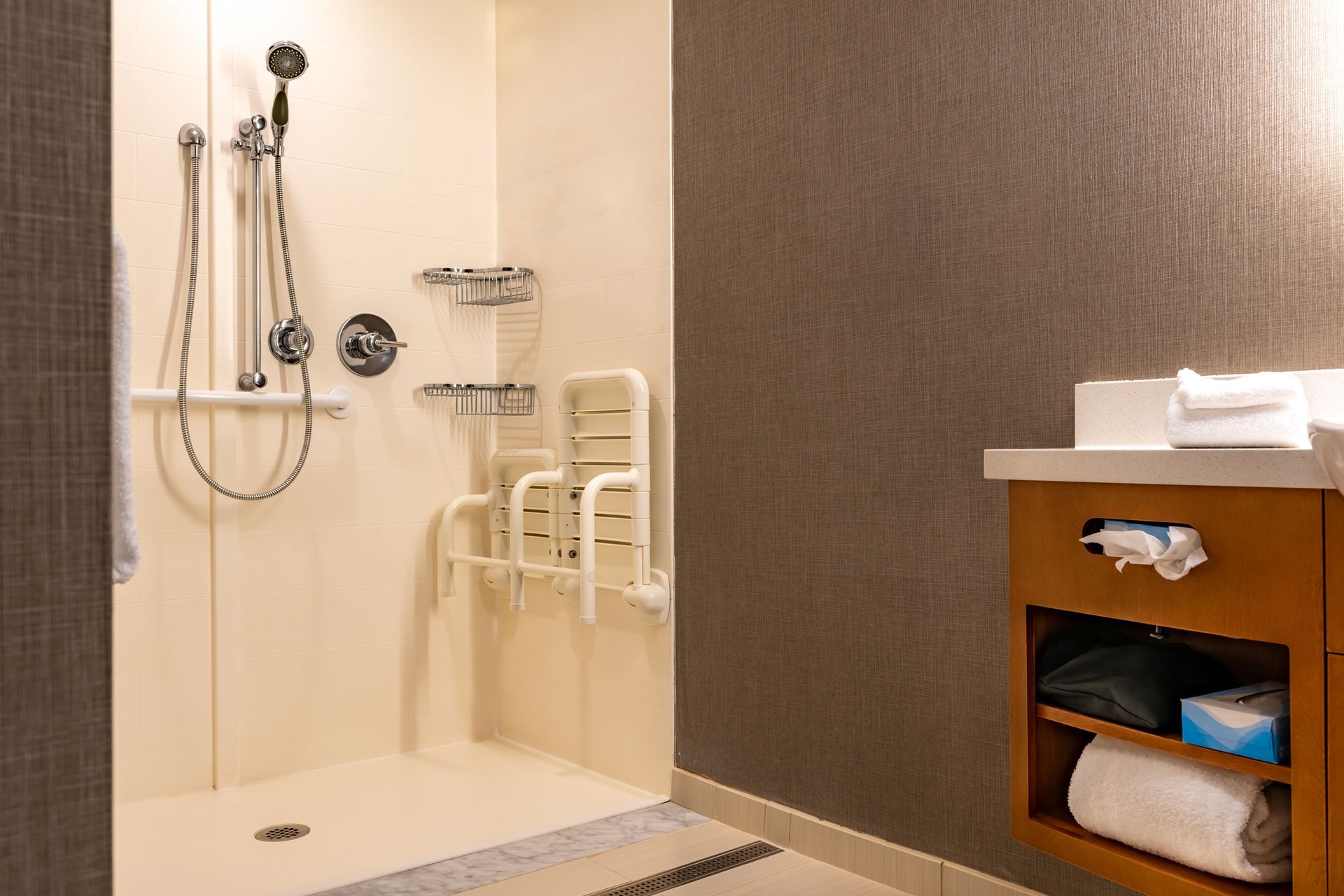 A bathroom with a walk in shower and a sink.