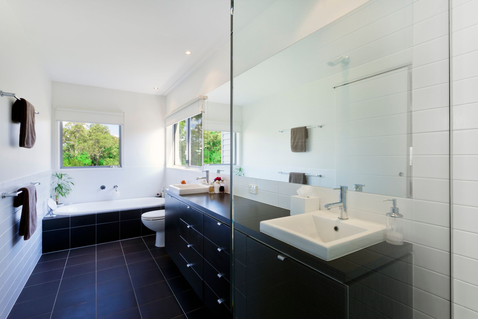 A bathroom with two sinks and a walk in shower