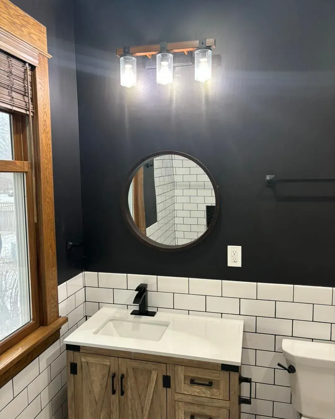 A bathroom with a sink , toilet and mirror.