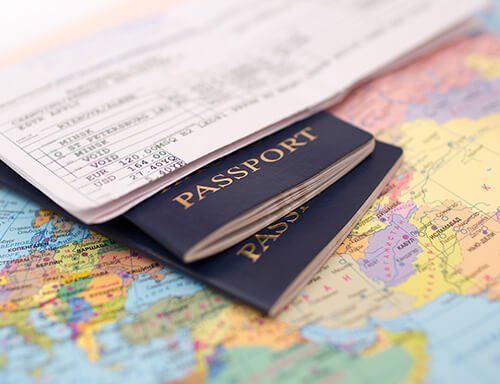 Three passports are sitting on top of a map of the world.