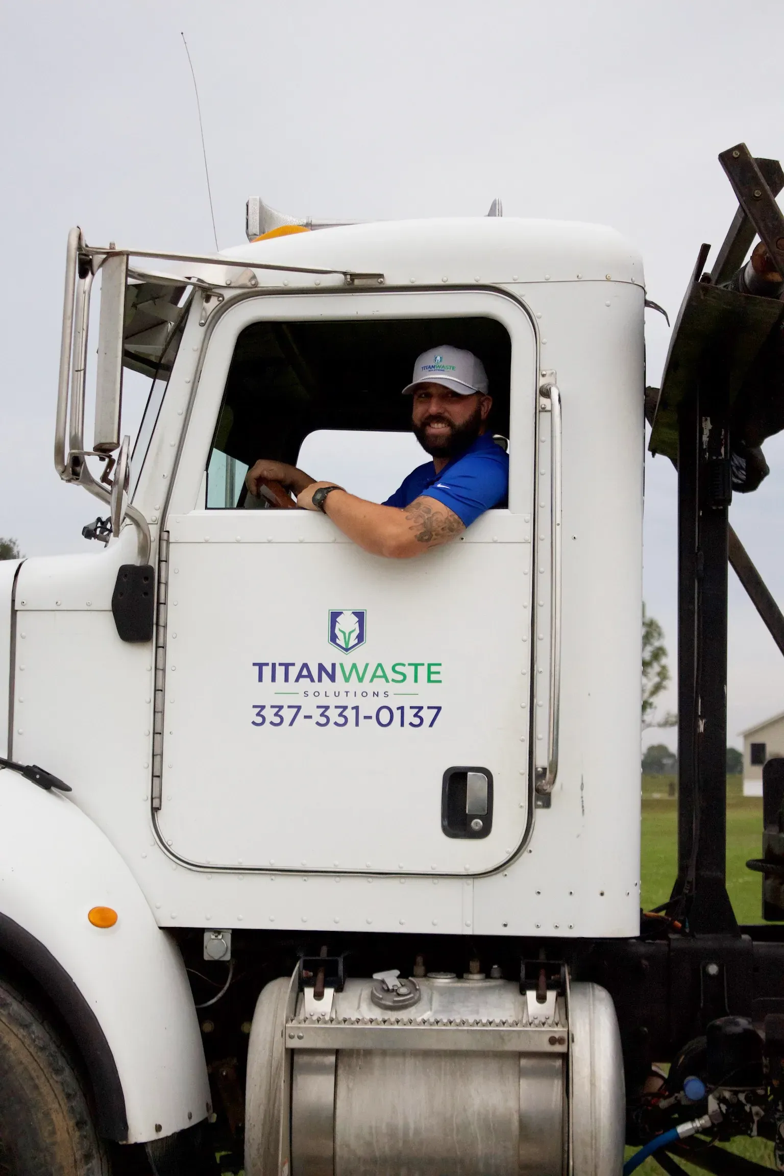 A man is driving a titan waste truck