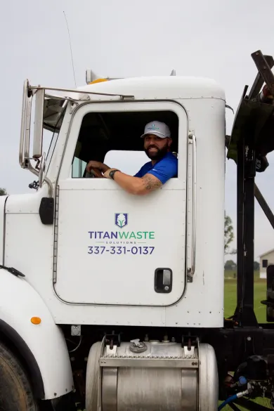 A man is driving a titan waste truck