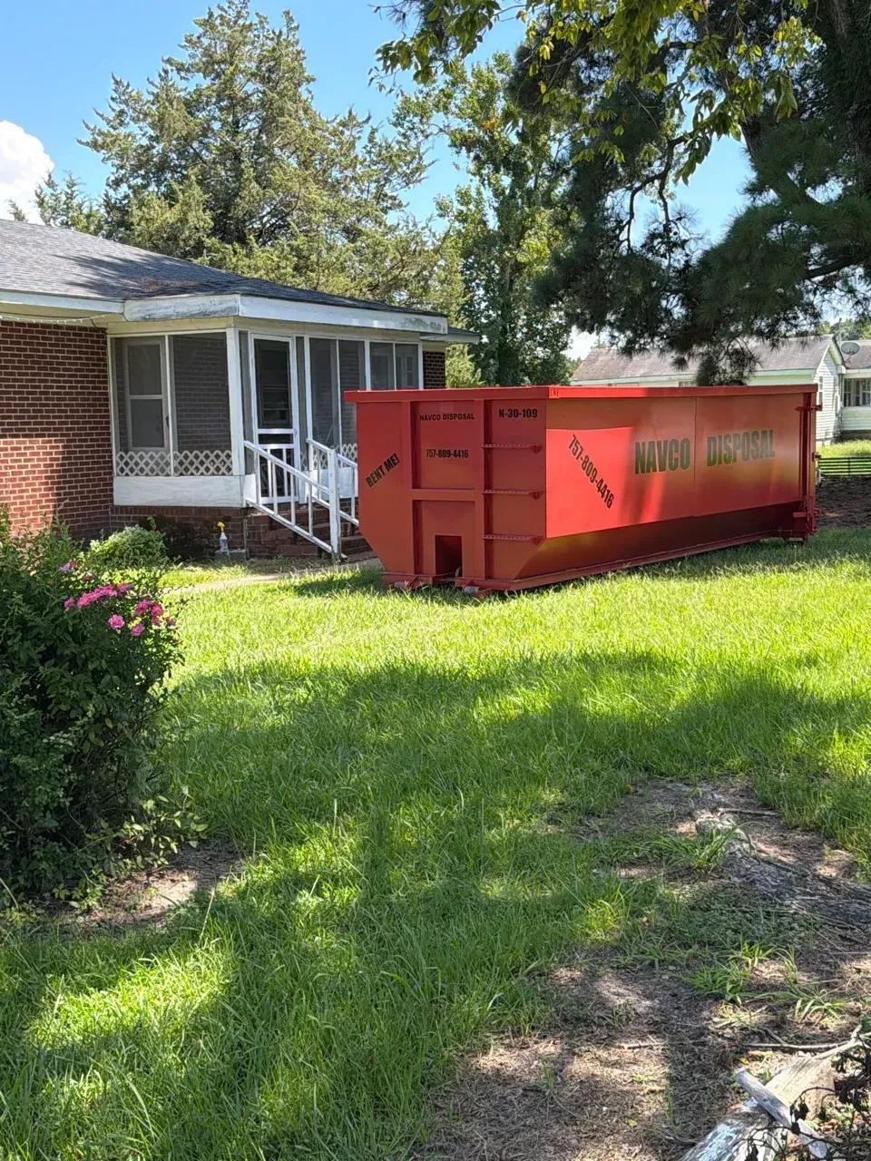 Red dumpster filled in an open outdoor area