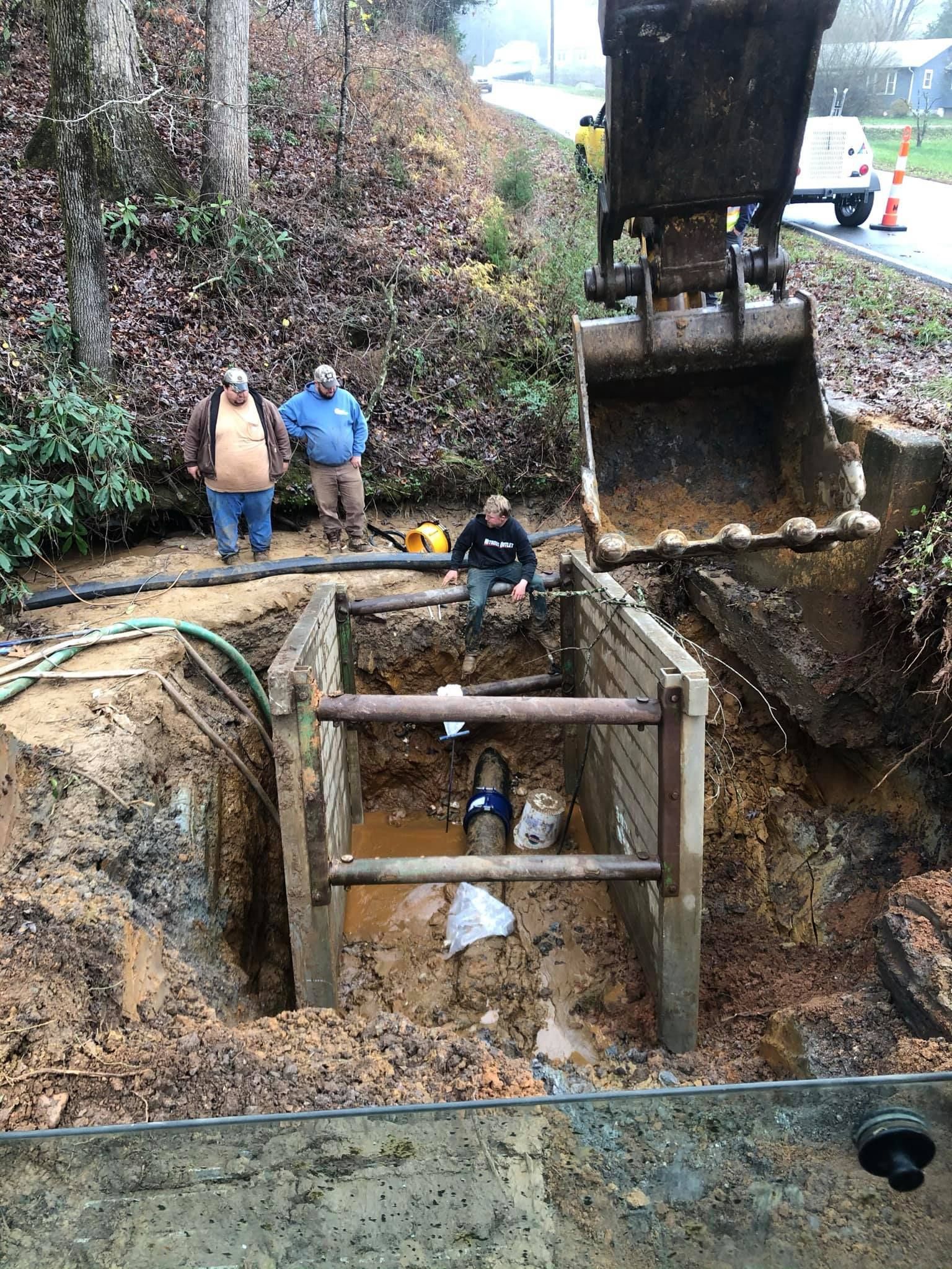 A group of men are digging a hole in the ground.