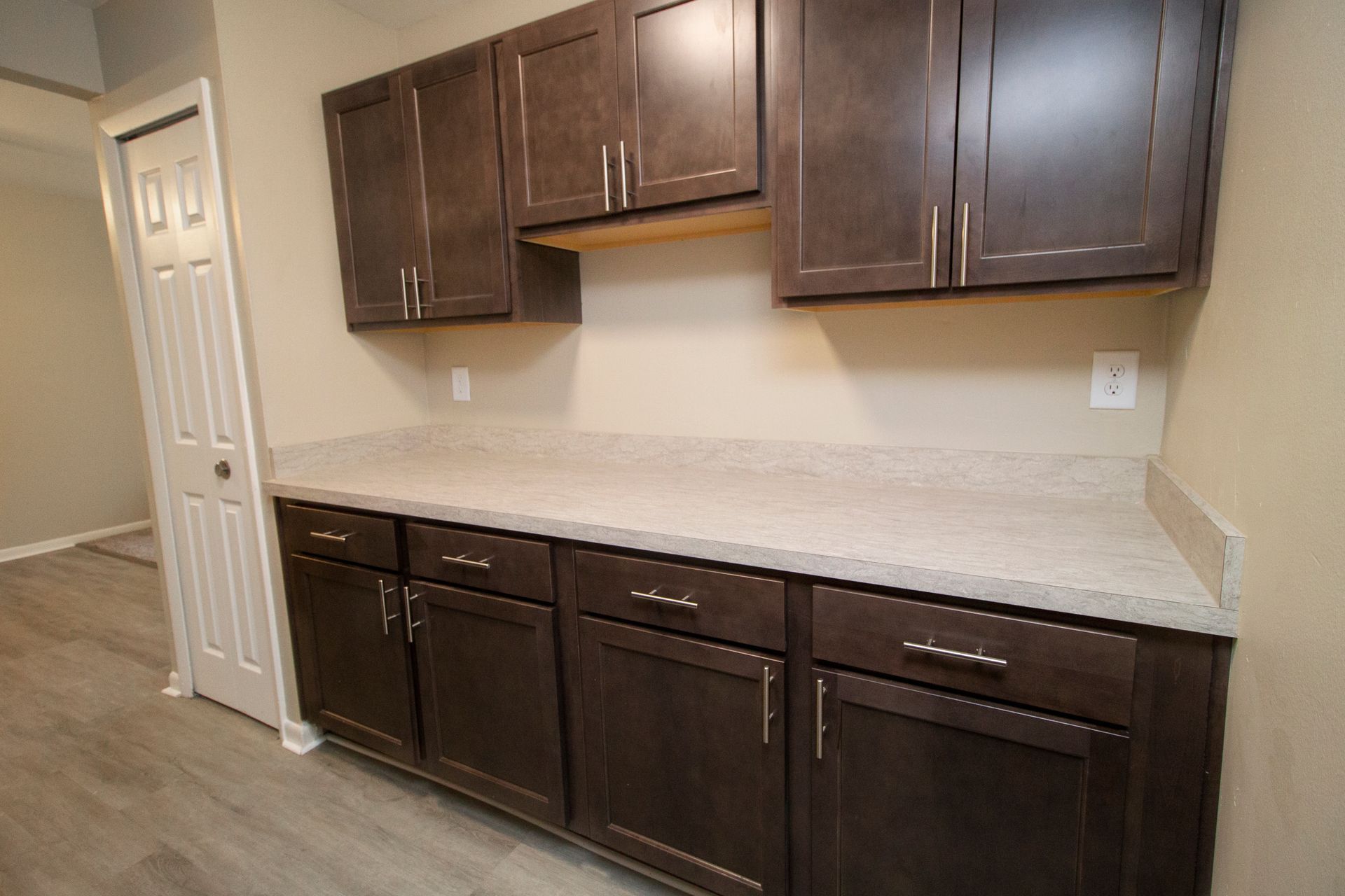 A kitchen with brown cabinets and white counter tops.