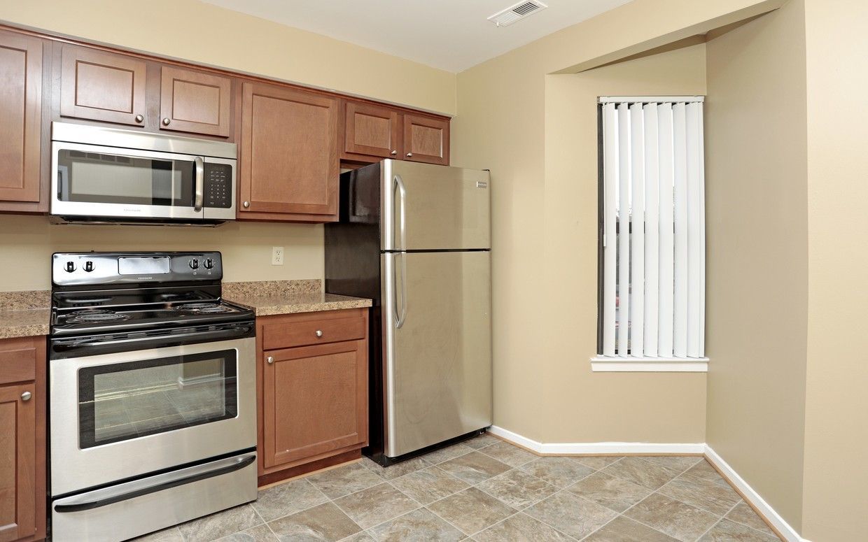 A kitchen with stainless steel appliances and wooden cabinets