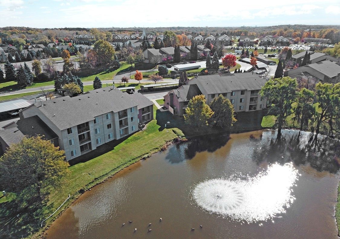 An aerial view of a lake surrounded by buildings and trees.