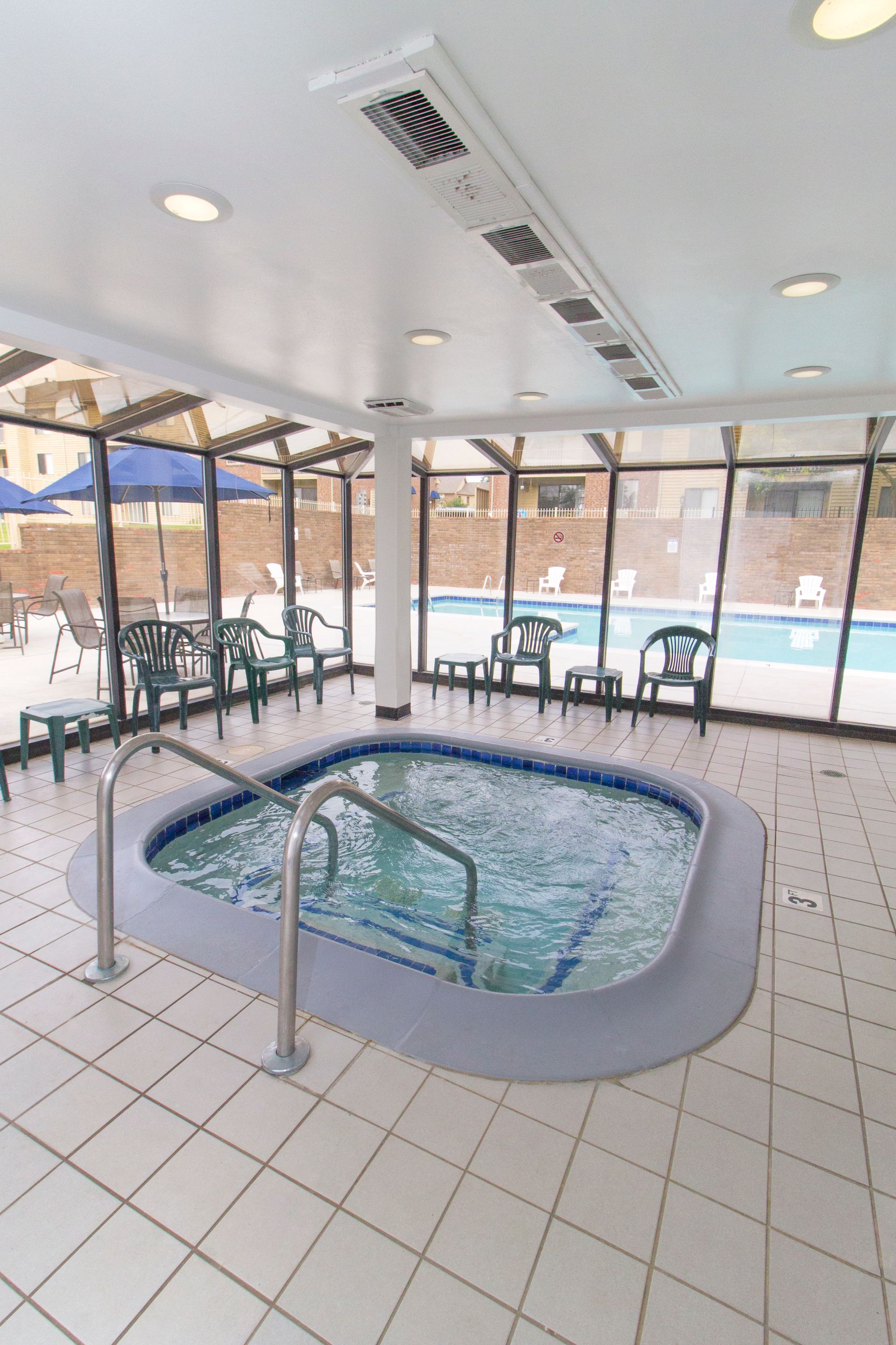 A swimming pool with a hot tub in the middle of it