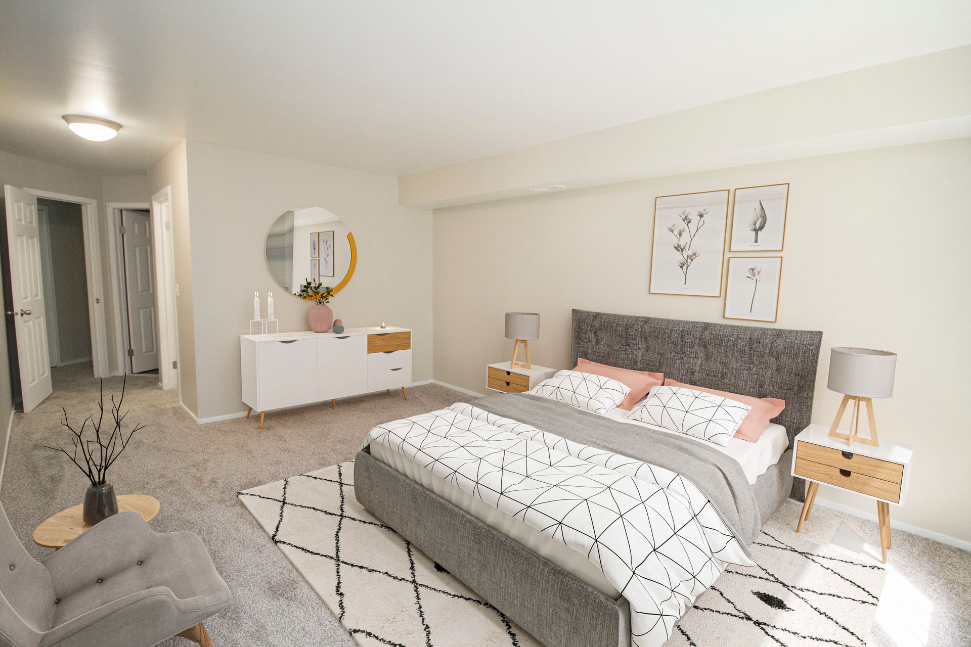 A bedroom with a large bed , nightstands , a chair and a mirror.