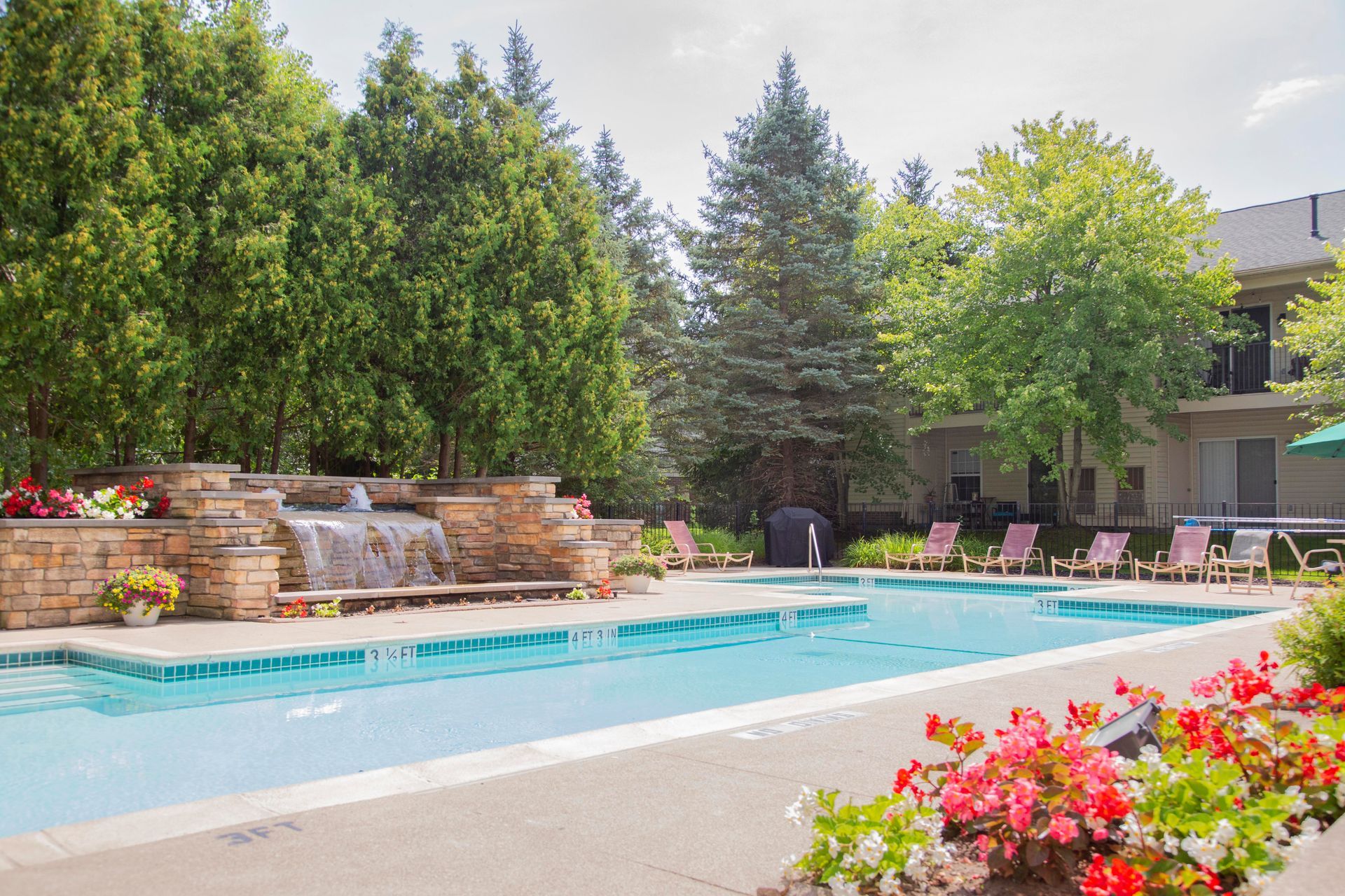 There is a large swimming pool with a waterfall in the middle of it.