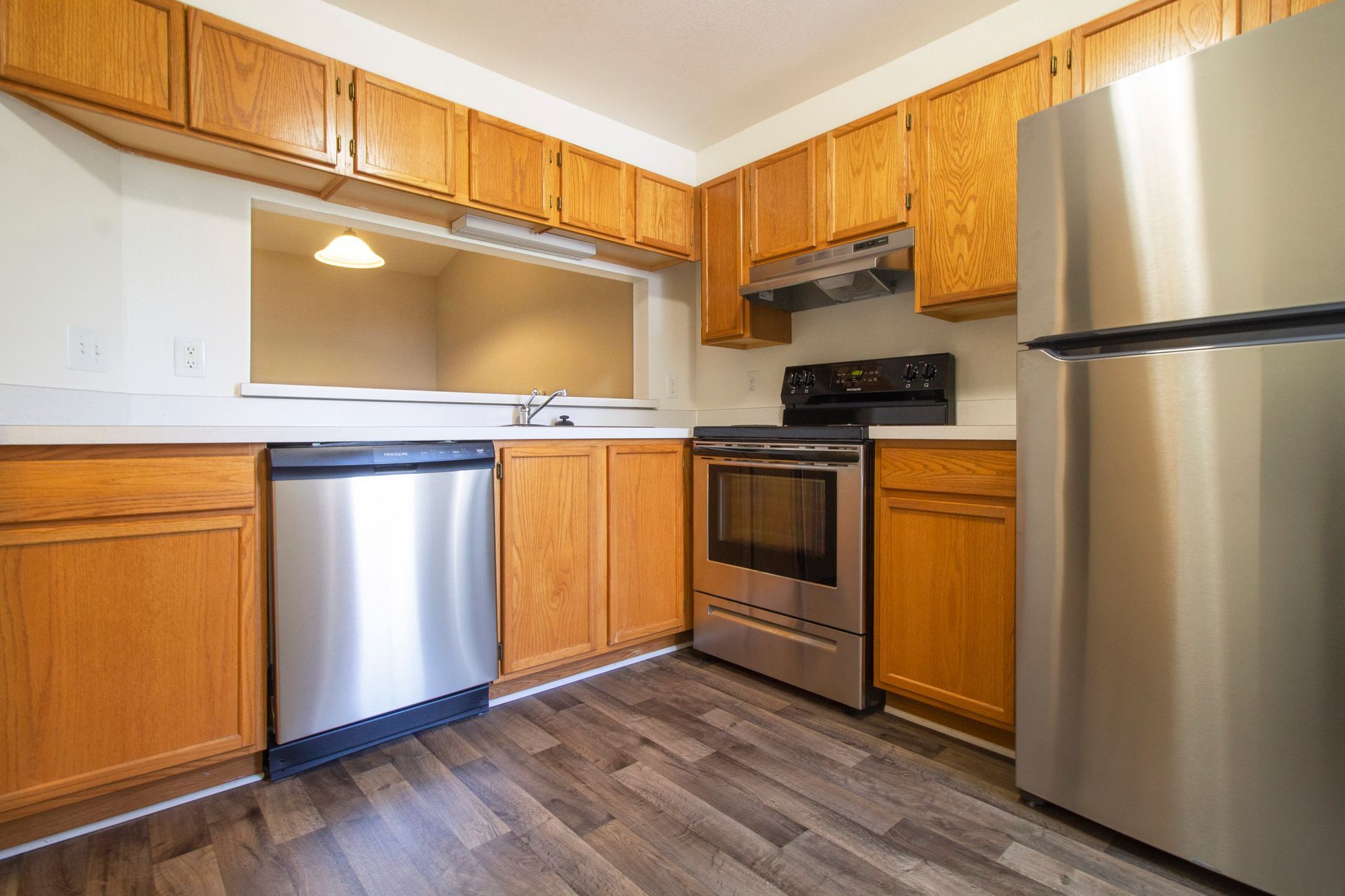 A kitchen with stainless steel appliances and wooden cabinets.